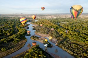 Hot air balloons drifting over the Rio Grande river in Albuquerque New Mexico